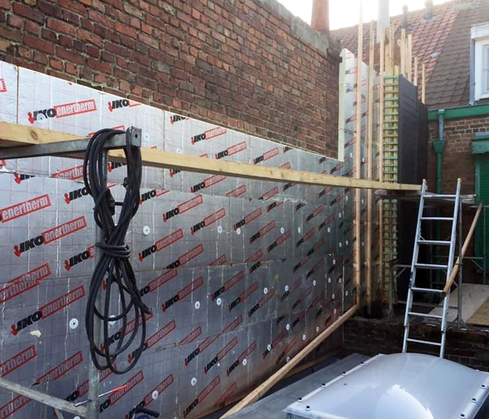 Mise en place isolation contre mur avant le bardage complet